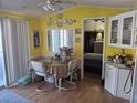 Bright dining area with yellow walls, laminate floors, and adjacent to a cozy bedroom at 50989 Highway 27 # 130, Davenport, FL 33897