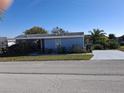 Exterior view of a cozy home featuring a well-kept lawn and mature landscaping at 50989 Highway 27 # 130, Davenport, FL 33897