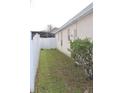 Narrow backyard with white picket fence, green grass, and some small bushes at 536 Dunoon St, Ocoee, FL 34761