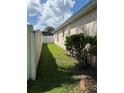 Narrow grassed side yard with white fence for privacy and minimal landscaping at 536 Dunoon St, Ocoee, FL 34761