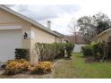 Side yard with green grass and trimmed hedges, offering a glimpse of the house's architectural details at 536 Dunoon St, Ocoee, FL 34761