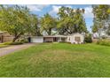 Charming single-story home with a lush green lawn and mature trees at 5569 Jessamine Ln, Orlando, FL 32839
