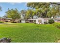 Beautiful single-story home with manicured lawn, driveway, and trees at 5569 Jessamine Ln, Orlando, FL 32839