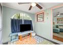 Relaxing porch with a TV, blue curtains, and colorful rug, perfect for outdoor entertainment at 7 Clarendon Ct, Daytona Beach, FL 32118