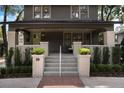 Inviting front porch with brick columns and planters and a bright doorway at 718 E Livingston St, Orlando, FL 32803