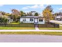 This single-story home boasts a well-maintained lawn, black picket fence, and lovely curb appeal at 864 Naples Dr, Orlando, FL 32804