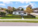 The house has a well-manicured lawn and a charming black picket fence, and lovely curb appeal at 864 Naples Dr, Orlando, FL 32804