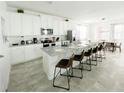 Eat-in kitchen features a large quartz island, stainless appliances and breakfast bar seating at 8914 Caroline Bay Ct, Kissimmee, FL 34747