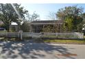 Charming single-story home with a white picket fence and screened porch at 933 Lakehurst St, Lakeland, FL 33805