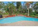 Resort-style pool with a rock border, tropical foliage, and lush landscaping at 1113 Lyric Dr, Deltona, FL 32738