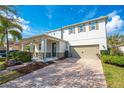 Charming two-story home with a covered porch, well-manicured lawn, and a brick-paved driveway at 11604 Acosta Ave, Orlando, FL 32836