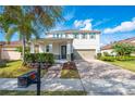 Charming two-story home with a well-manicured lawn, beautiful landscaping, and a brick-paved driveway at 11604 Acosta Ave, Orlando, FL 32836