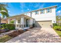 Charming two-story home with a covered porch, well-manicured lawn, and a brick-paved driveway at 11604 Acosta Ave, Orlando, FL 32836