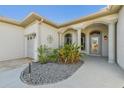 Home entrance featuring a welcoming front door, beautiful columns, and well-maintained landscaping at 12018 Se 175Th Loop, Summerfield, FL 34491