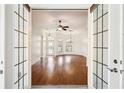 A view through the French doors shows hardwood flooring, a chandelier, and lots of natural light at 12018 Se 175Th Loop, Summerfield, FL 34491
