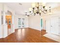 A view of the bright living room shows hardwood floors, neutral walls, and decorative columns at 12018 Se 175Th Loop, Summerfield, FL 34491