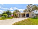 Charming single-story home with well-manicured lawn, beautiful landscaping, and attached carport at 1226 E Schwartz E Blvd, Lady Lake, FL 32159