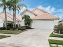 Welcoming single-Gathering home with a beautiful lawn, colorful landscaping, and a convenient two-car garage at 13336 Lake Turnberry Cir, Orlando, FL 32828