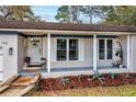 Inviting front porch with decorative plants, pendant lighting, and a swing seat at 142 Habersham Dr, Longwood, FL 32779