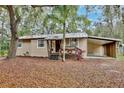 Charming tan home featuring a front yard covered in leaves and a covered carport at 14226 Nell Dr, Orlando, FL 32832