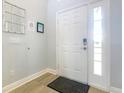 Clean and bright entryway with a white front door, light gray walls, and modern flooring and fixtures at 1520 Solana Cir, Davenport, FL 33897