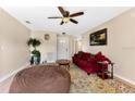 Comfortable living room featuring a decorative ceiling fan, a large window, and a view of other rooms at 1716 Terry Ne Cir, Winter Haven, FL 33881