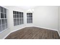 Bright dining room with hardwood floors, modern chandelier, and natural lighting at 1721 Sandalwood Sw Cir, Winter Haven, FL 33880