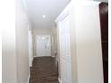 Welcoming hallway with tiled floors, neutral paint, white trim, and a closet at 1721 Sandalwood Sw Cir, Winter Haven, FL 33880