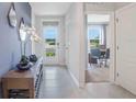 Inviting entryway with neutral-colored tiled floor, console table, and view into the office space at 177 Highland Dr, Deltona, FL 32738