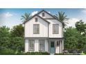 Inviting two-story farmhouse featuring a white exterior with gray trim, a welcoming front porch and lush landscaping at 1975 Iorio St, St Cloud, FL 34771