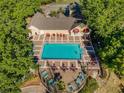 Aerial shot of a beautiful community pool with lounge chairs, tables, and lush landscaping under a clear blue sky at 2019 Dixie Belle Dr # 2019W, Orlando, FL 32812