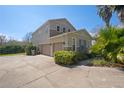 Two-story home showcasing a spacious driveway, two-car garage, neutral color palette, and landscaped front yard at 2040 Touchwood Ct, Apopka, FL 32712