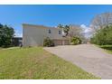 Rear exterior view showing a two-story house with a large driveway and spacious grassy area at 2040 Touchwood Ct, Apopka, FL 32712