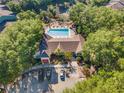 Aerial view of community clubhouse with a sparkling pool, lounge chairs, and convenient parking at 2047 Dixie Belle Dr # 2047K, Orlando, FL 32812