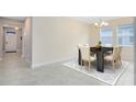 Bright dining room with a black table, 6 beige chairs, tile floor, and a gray and white rug at 2930 Wordsmith Rd, Kissimmee, FL 34746