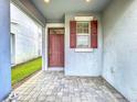 Cozy front porch with a stylishly colored front door and adjacent window with matching shutters at 3088 Prelude Ln, Kissimmee, FL 34746