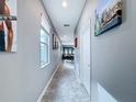 Bright hallway features tile floors, neutral walls, and an array of artwork creating an inviting atmosphere at 3088 Prelude Ln, Kissimmee, FL 34746