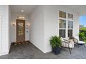 Inviting front porch with white brick, seating, and a beautifully landscaped entrance at 3135 Vanguard Ct, St Cloud, FL 34771