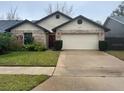 Charming single-story home with well-maintained lawn and an attached two-car garage at 3210 Little Oak Way, Orlando, FL 32812