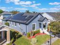 Aerial view of blue single-Gathering home with solar panels and a well-maintained lawn at 3320 Ashmount Dr, Orlando, FL 32828