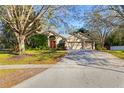 Charming one-story home featuring a well-manicured lawn, mature trees, and a three-car garage at 3443 Players Point Loop, Apopka, FL 32712