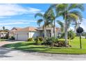 Well-maintained home on a corner lot, featuring palm trees and a meticulously kept lawn at 4068 Stone Creek Loop, Lake Wales, FL 33859