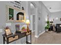 Inviting entryway with light wood floors, a decorative mirror, and an arched doorway at 408 Orista Dr, Davenport, FL 33897