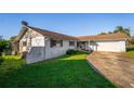 Single story home with a stone facade and a well maintained lawn in a suburban setting at 8430 Pamlico St, Orlando, FL 32817