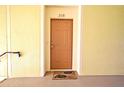 Front door of unit 208 with yellow wall at 8775 Sartori St # 208, Orlando, FL 32829