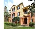 Multi-story condo building with screened balconies and lush tropical landscaping at 8775 Sartori St # 208, Orlando, FL 32829