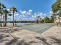 Outdoor tennis court surrounded by lush landscaping with a partial view of the lake at 942 Lake Destiny Rd # B, Altamonte Springs, FL 32714