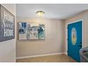 Welcoming foyer with tile flooring, a decorative painting, and a vibrant blue door at 113 Wheatland Ct, Longwood, FL 32779