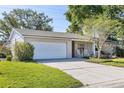 A charming single-story house with a two-car garage and a well-maintained lawn at 116 Cambridge Dr, Longwood, FL 32779