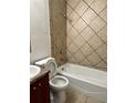 Tiled bathroom featuring a shower-tub combination and a modern vanity at 1352 Sw 69Th Rd, Bushnell, FL 33513
